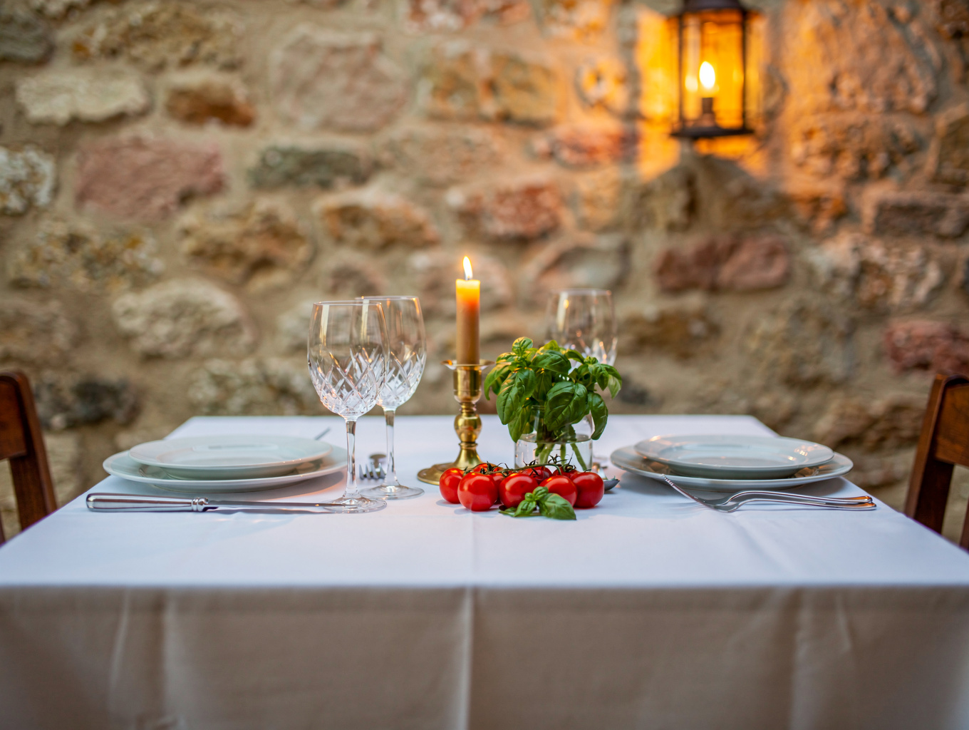 Candlelit dining tables with linen and wine glasses at MISTO